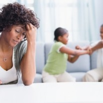 Frustrated African American mother with children fighting